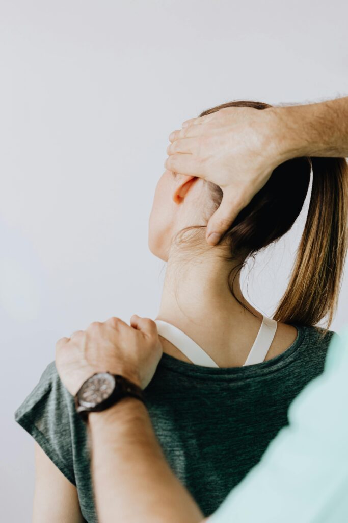 pexels-photo-4506164-4506164 Back view of crop faceless chiropractor in wristwatch stretching neck of unrecognizable female patient during medical examination in doctor office in clinic